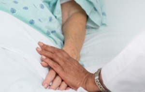 Doctor holding patient's hand in hospital.
